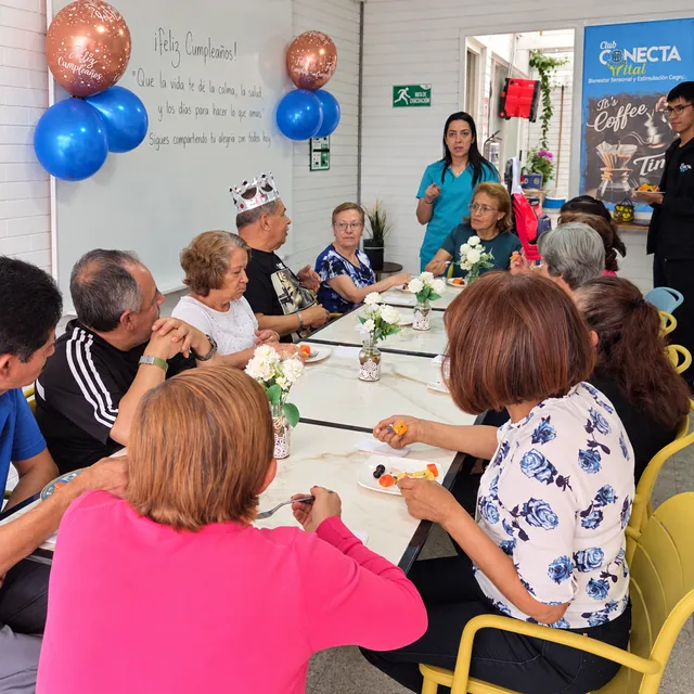 Personas mayores comparten una celebración de cumpleaños en Conecta Vital