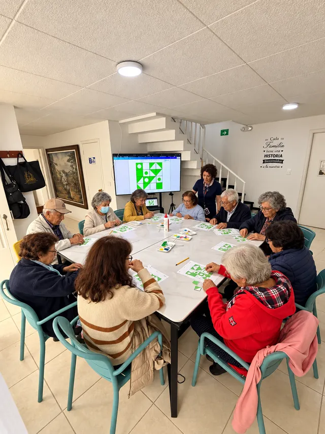 Personas mayores realizan ejercicios con figuras geométricas en un taller grupal de estimulación cognitiva