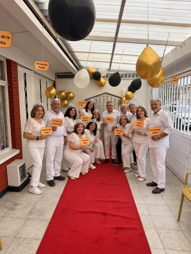 Grupo de personas celebra con coronas y mensajes positivos sobre una alfombra roja