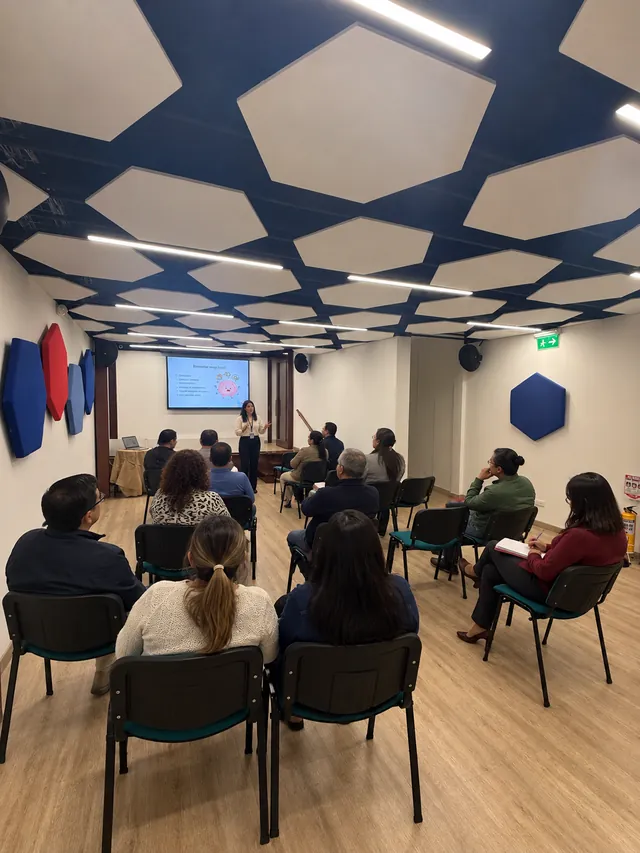 Personas asisten a una capacitación sobre bienestar emocional en un auditorio